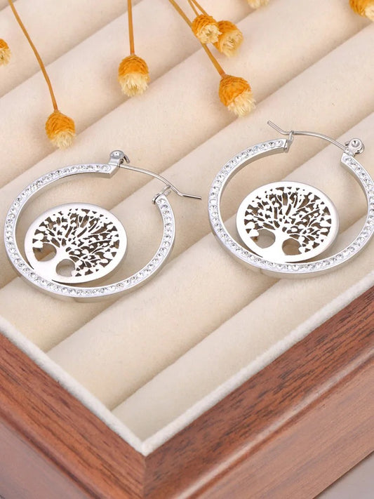Boucle D'oreille Arbre De Vie Créole Originale présenté sur une boite à bijoux en bois avec tissu beige.