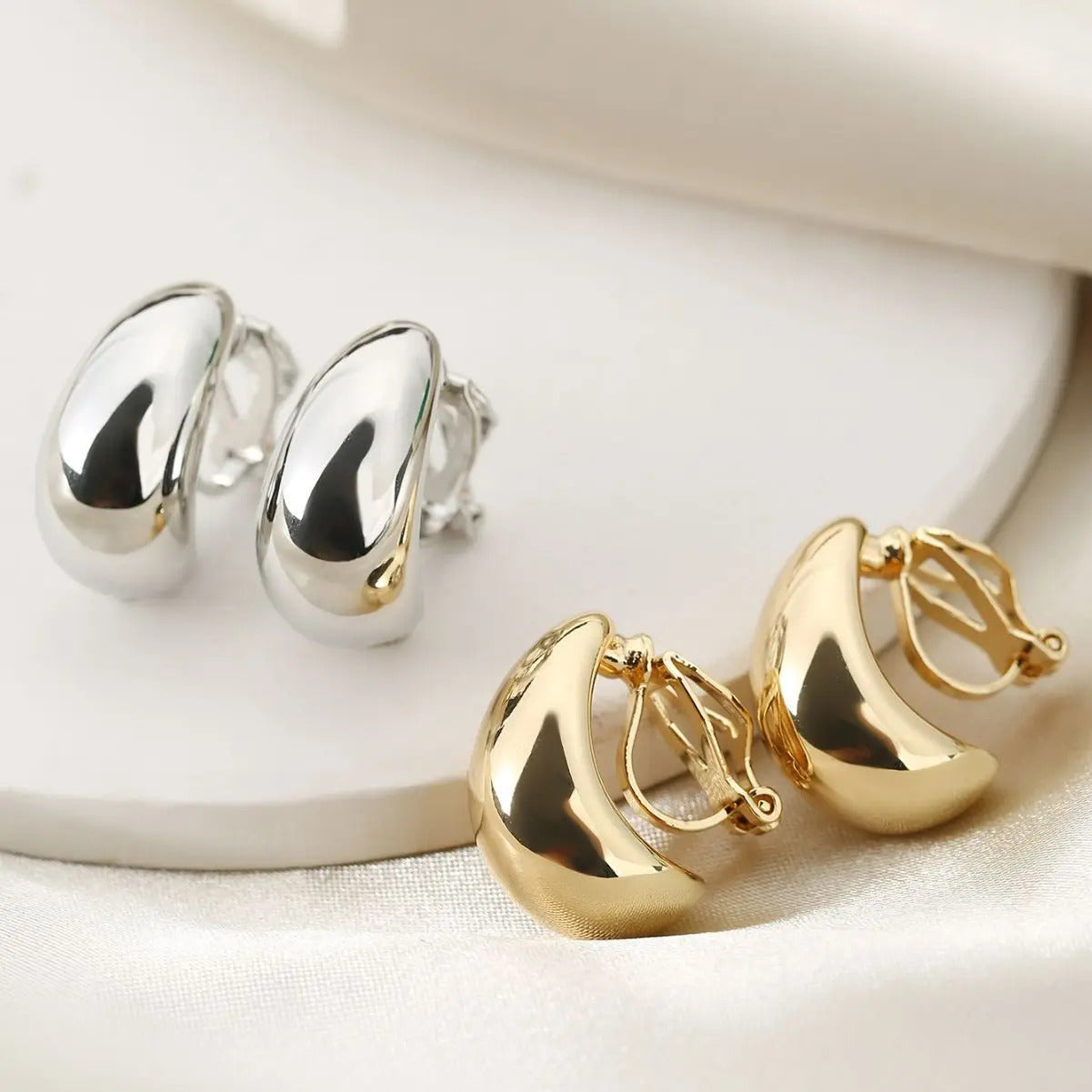 Boucle d'Oreille Clip Femme en Forme de Gouttelette posé sur une table