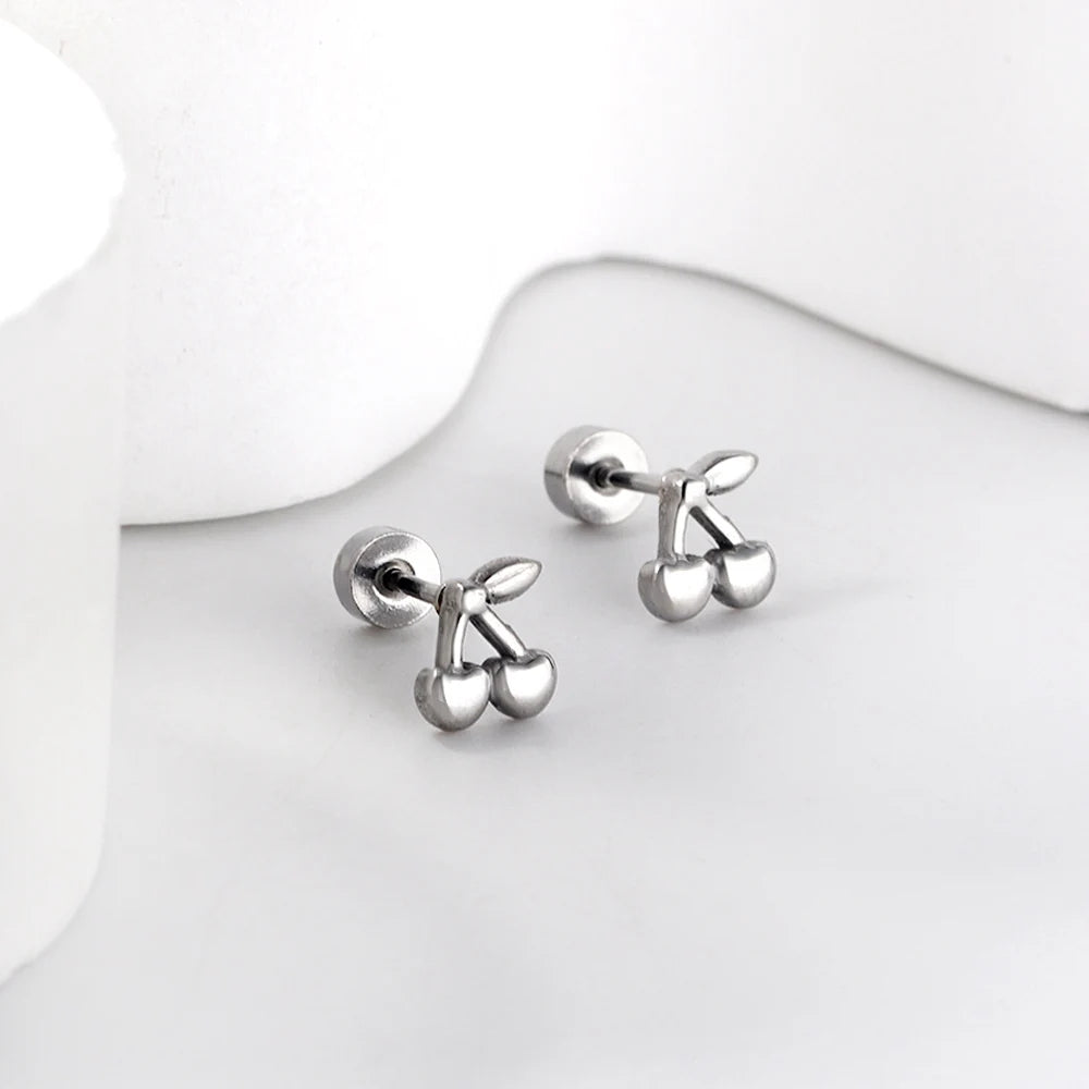 Boucle d'Oreille Enfant Acier Inoxydable Cerises, présenté sur un plan de travail gris très clair.