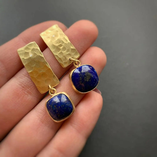 Boucle D'oreille Femme Pendante Dorée et Bleu présentés sur la main d'une femme.