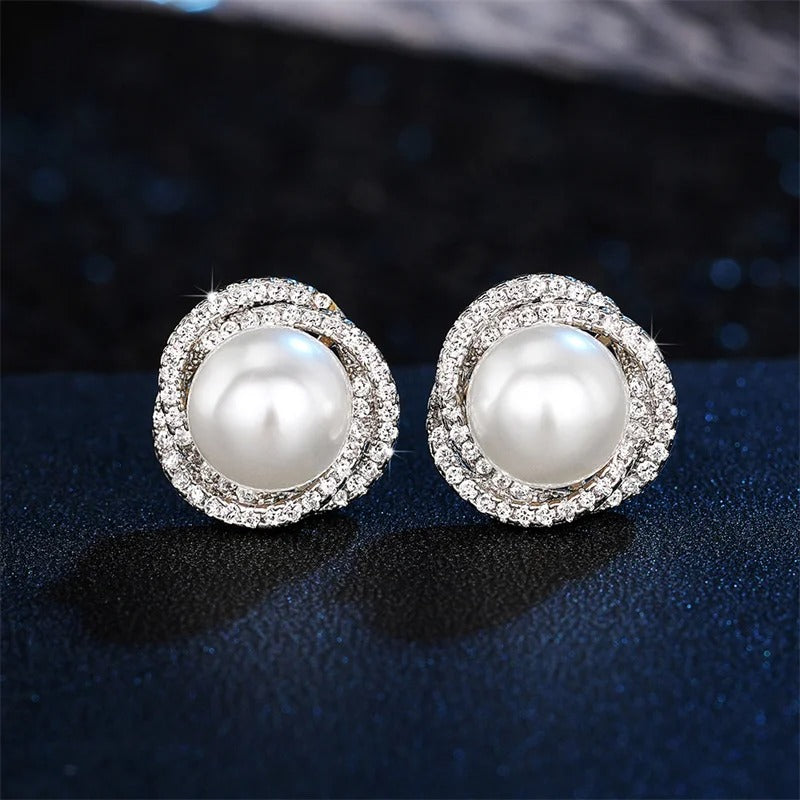 Boucle d'Oreille Femme Perle Design Croisé sur fond bleu