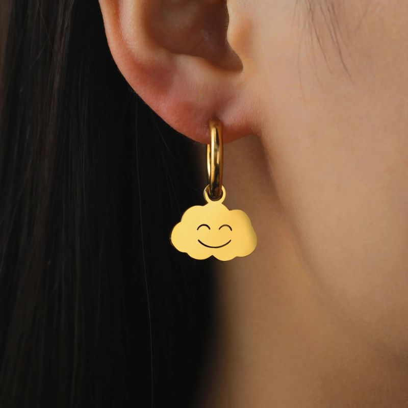 Boucle D'oreille Fillette Pendante Nuage, portée par une jeune fille, on voit son lobe d'oreille, le haut de son cou et ses cheveux.