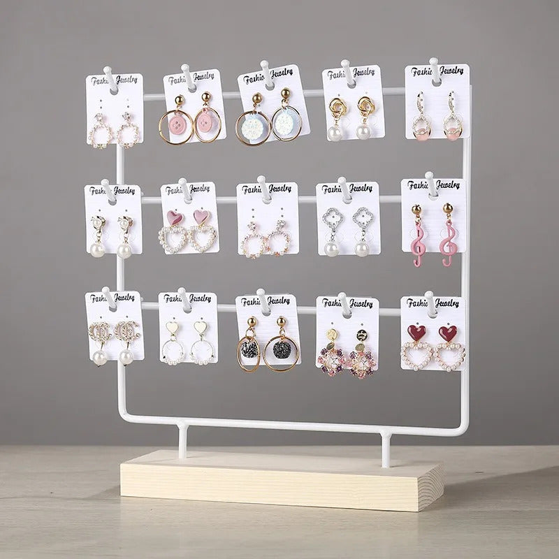 Porte Boucle D'oreille avec Quinze Petits Crochets posé sur une table avec un fond gris