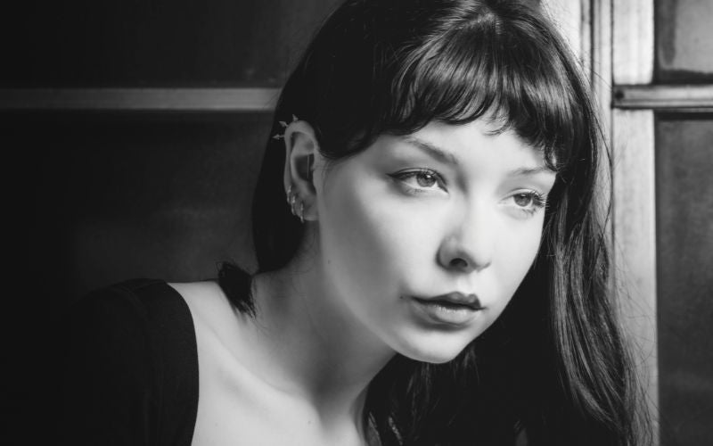 Femme prise ne photo noir et blanche, elle porte 3 créoles sur une oreille que l'on voit Image