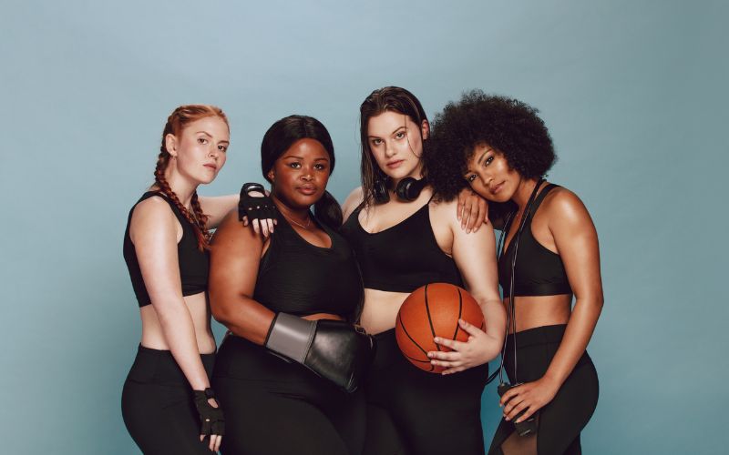 Groupe de femme en tenue de sport noire, elles portent des boucles d'oreilles et des accessoires lié au sport qu'elles pratiuqent Image