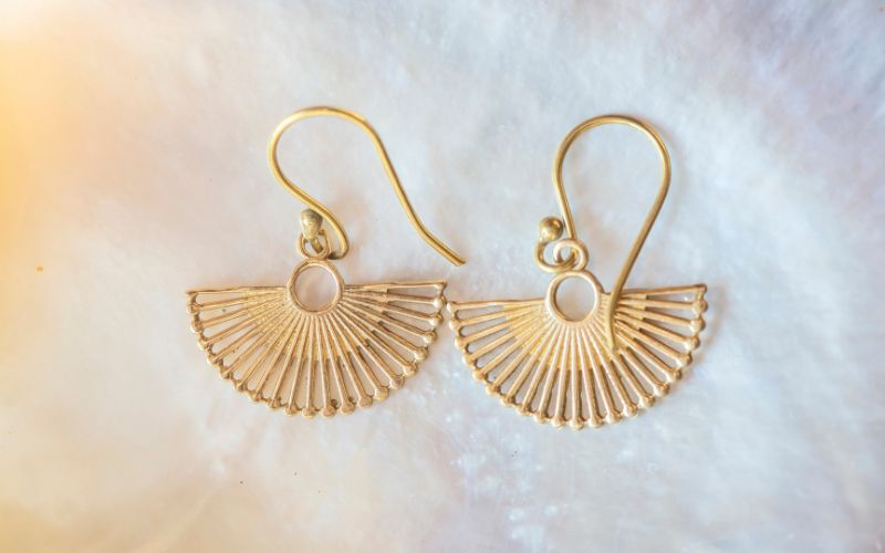 Boucle d'oreille doré tendance à enfiler, en forme d' éventail luxueux. Image