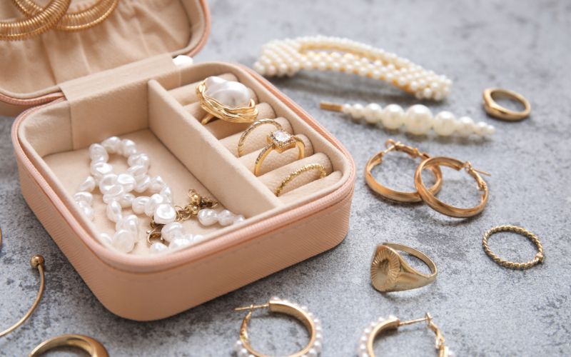Boite à boucle d'oreille et bijoux de voyage, carré avec plusieurs rangements, elle est rose pâle. Image