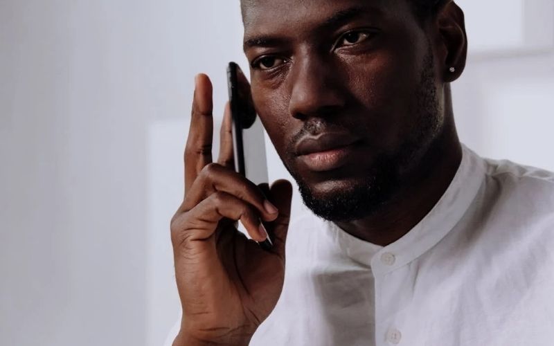 Homme au téléphone avec petite boucle d'oreille diamant Image