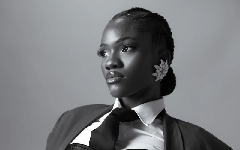 Photo en noir et blanc, femme coiffé d'un chignon bas, maquillée et habillé pour un shooting, avec un gros ear cuff en forme de fleur de "diamants"