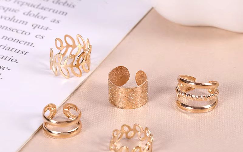 plusieurs ear cuff dorés posé sur une table  Image