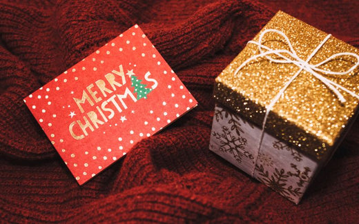 Carte cadeau rouge et cadeau pailleté, présentés sur un joli tissu rouge. Image