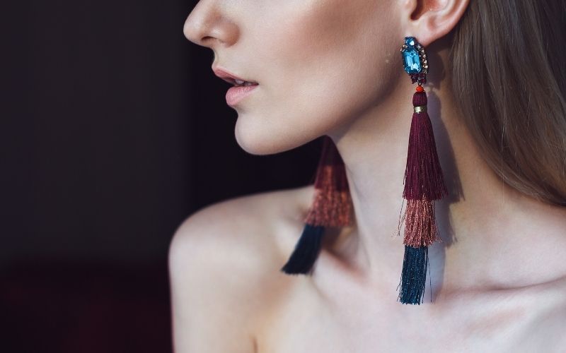 Mannequin de profil, on ne voit que le bas de son visage, elle porte des boucles d'oreilles over-size qui tombent sur ses clavicules Image