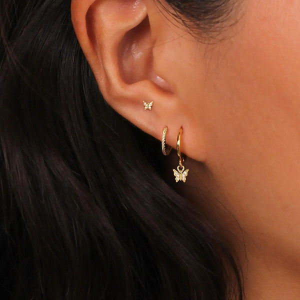 Boucle D'oreille 3 Trous Papillon Acier Inoxydable, portées par une femme on ne voit que son oreille