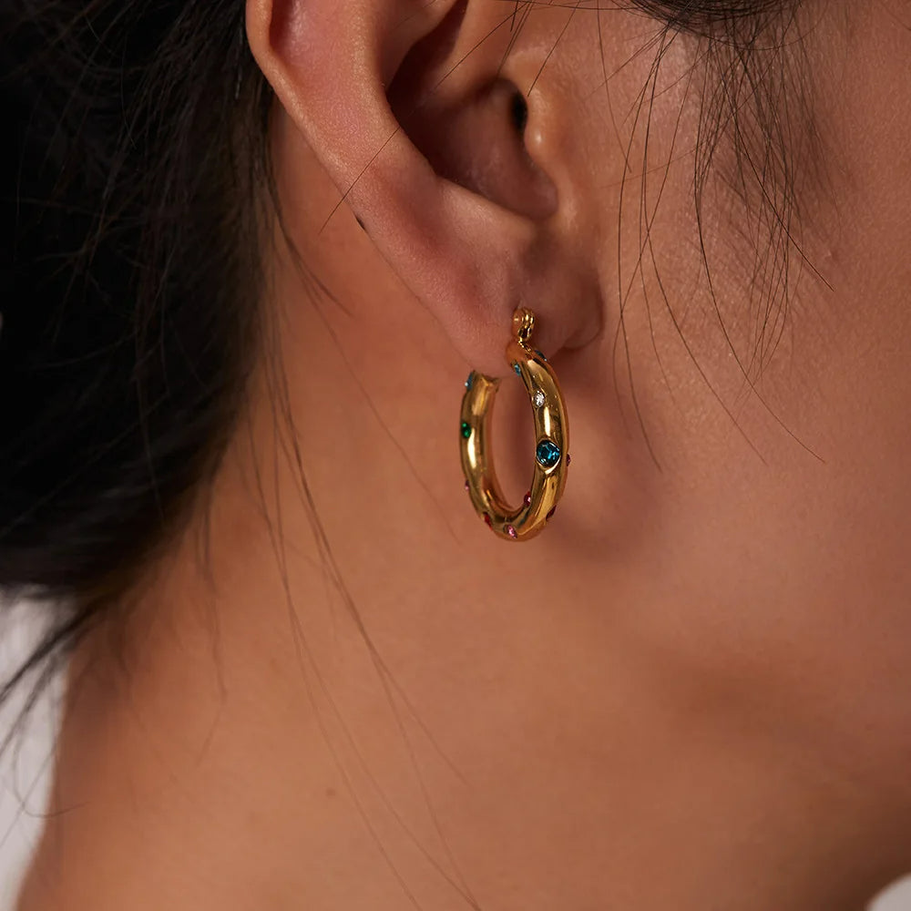 Boucle d'Oreille Acier Inoxydable Créole Dorée et Colorée porté par une femme de profil, on ne voit que son oreille et son cou.