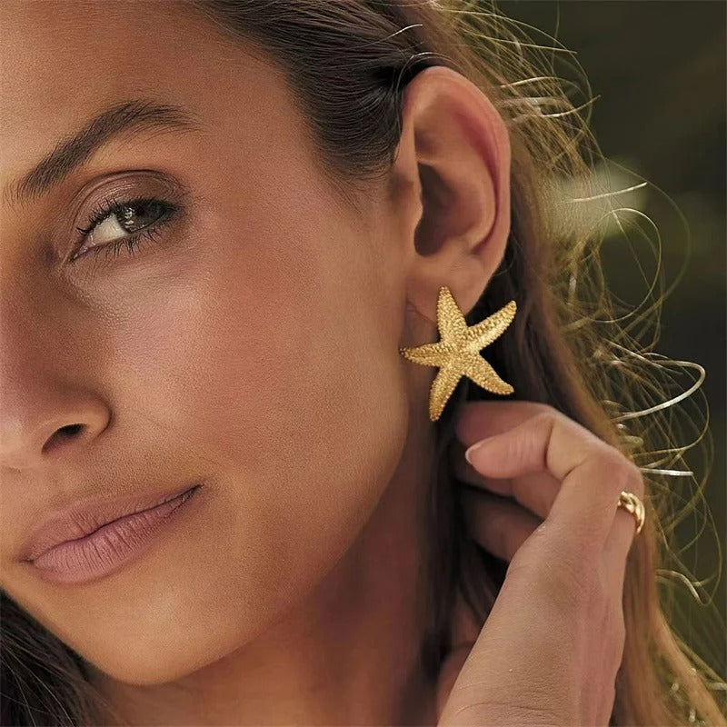 Boucle D'oreille Anneau Femme Coquillage Étoile, portée par une femme au teint halé