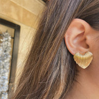 Boucle D'oreille Cœur Effet Coquillage, portée par une femme aux cheveux détachés, elle est de profil.