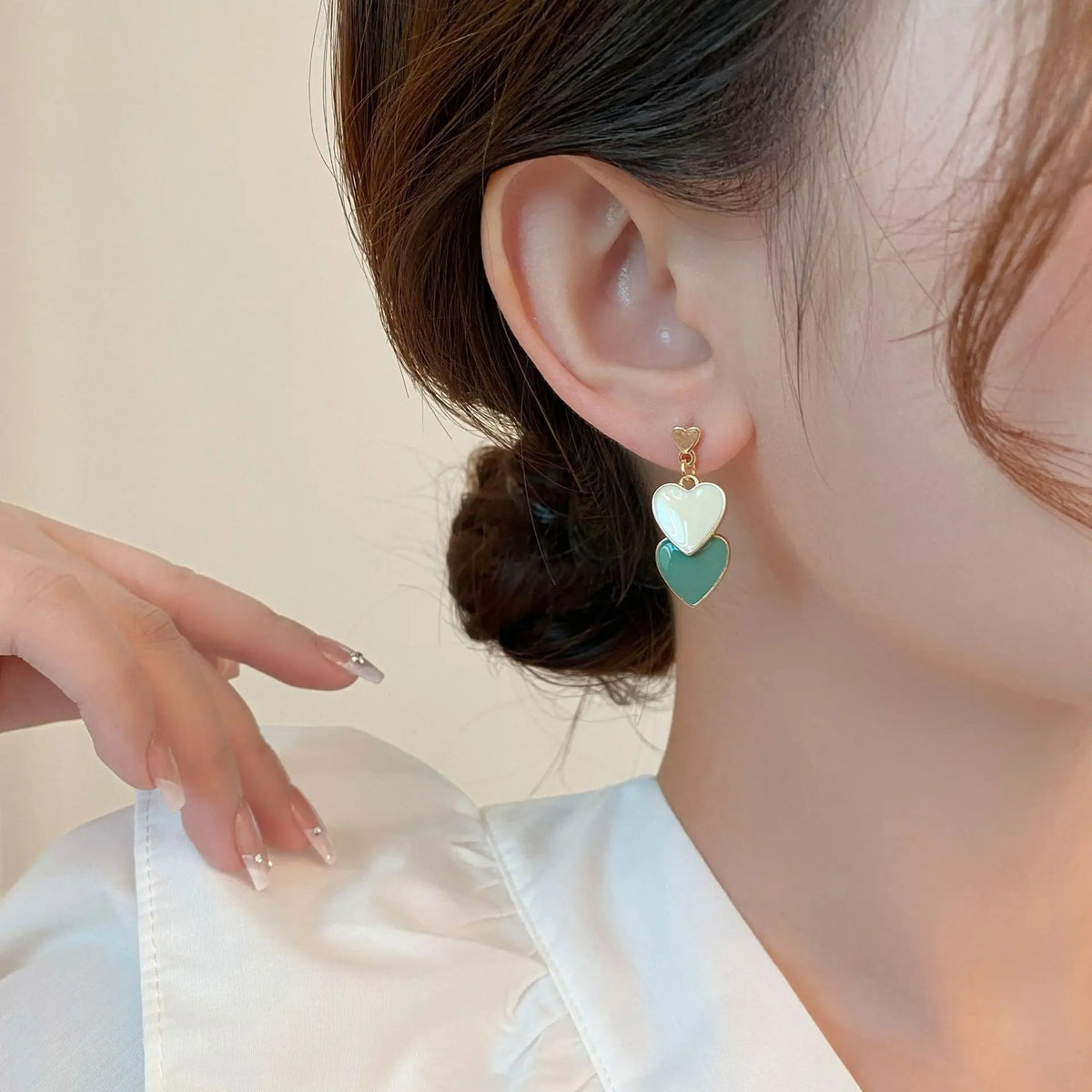 Boucle D'oreille Cœur Vert et Blanc porté par une femme de profil, on ne voit que son oreille