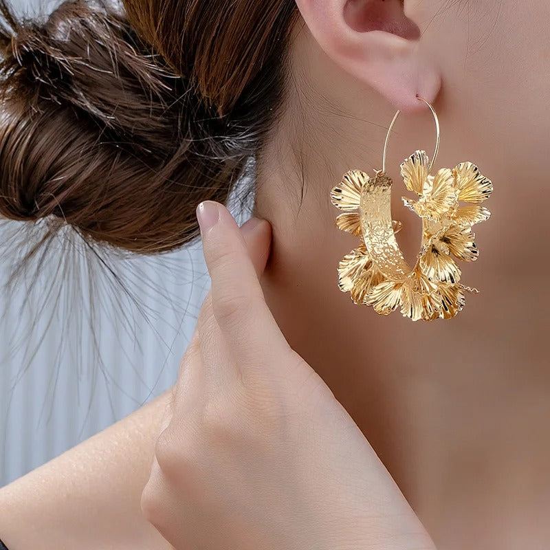 Boucle D'oreille Créole Originale Dorée Effet Floral, poetée par une femme de profil. Image