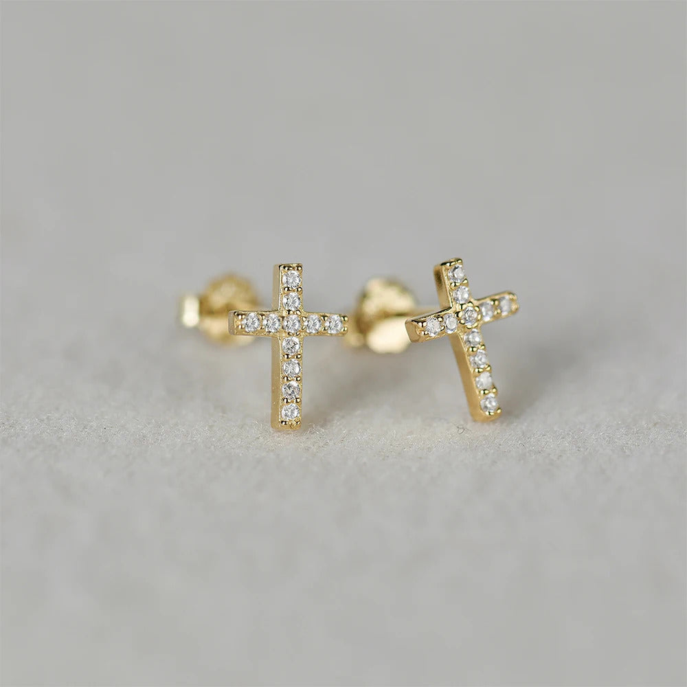 Boucle d'Oreille Croix Femme Doré et Tendanceposé sur un fond beige