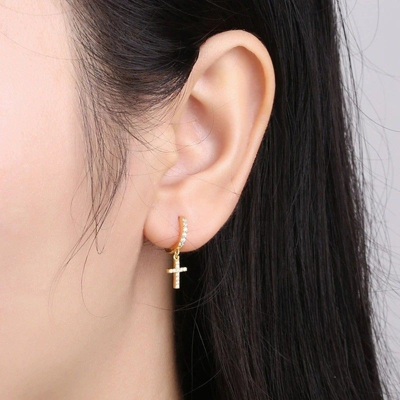 Boucle D'oreille Croix Femme Créole Luxe portée par une femme, on ne voit qu'une oreille
