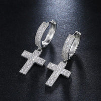 Boucle d'Oreille Croix Homme Argentée Pendante présenté sur fond noir 