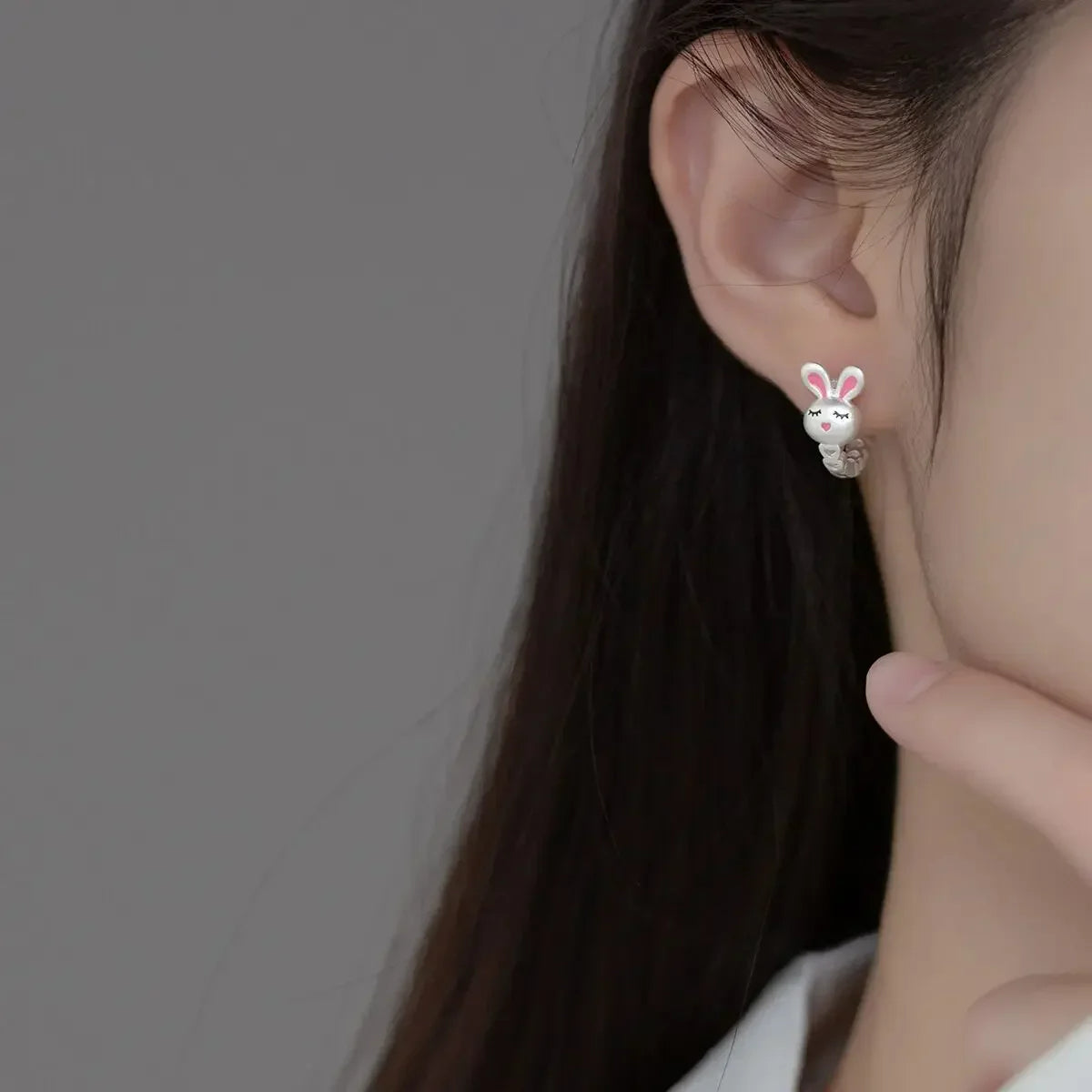 Boucle d'Oreille Enfant Créole Argentée Lapin, porté par une mannequin, on ne voit que son oreille, ses cheveux et son cou. Image