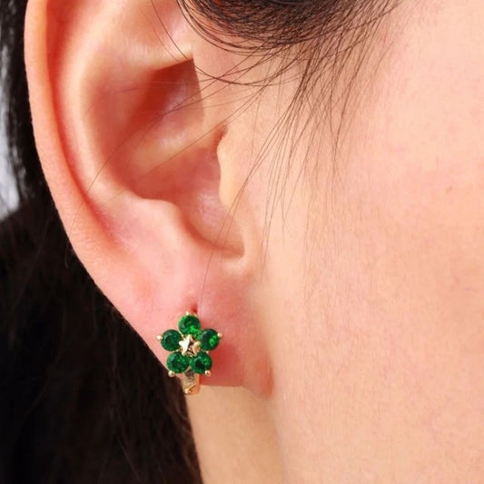 Boucle d'Oreille Enfant Créole Fleur Verte, portée par une jeune fille, on ne voit que son oreille.