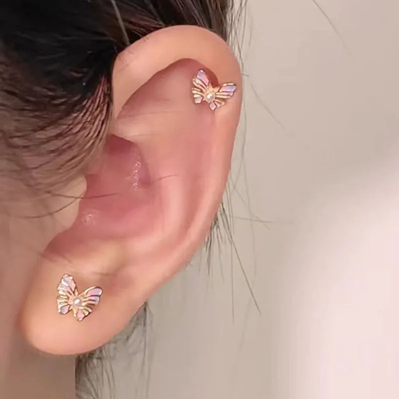 Boucle d'Oreille Enfant Papillon Acier Inoxydable, portée par une mannequin, une boucle sur le lobe et une autre sur le cartilage haut de l'oreille.