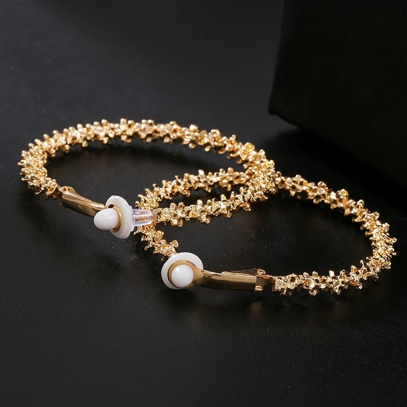 Boucle d'Oreille Femme Créole à Clipser Vintage posé sur un fond noir 
