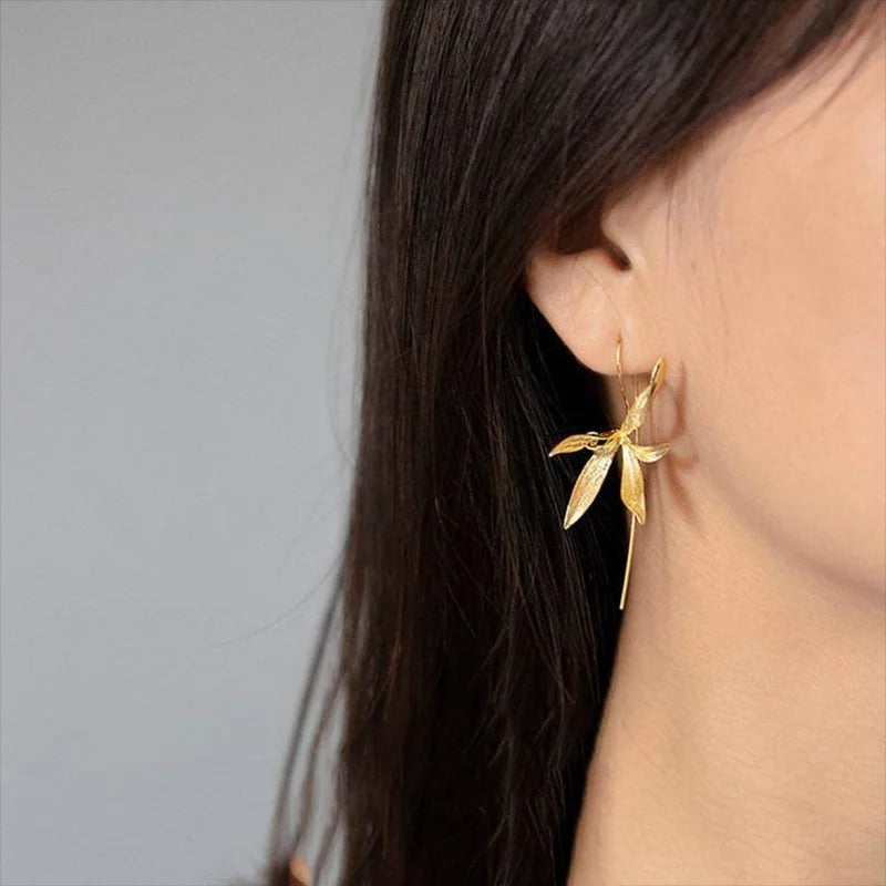 Boucle D'oreille Fleur Pendante porté par une femme de profil les cheveux noir détachés.