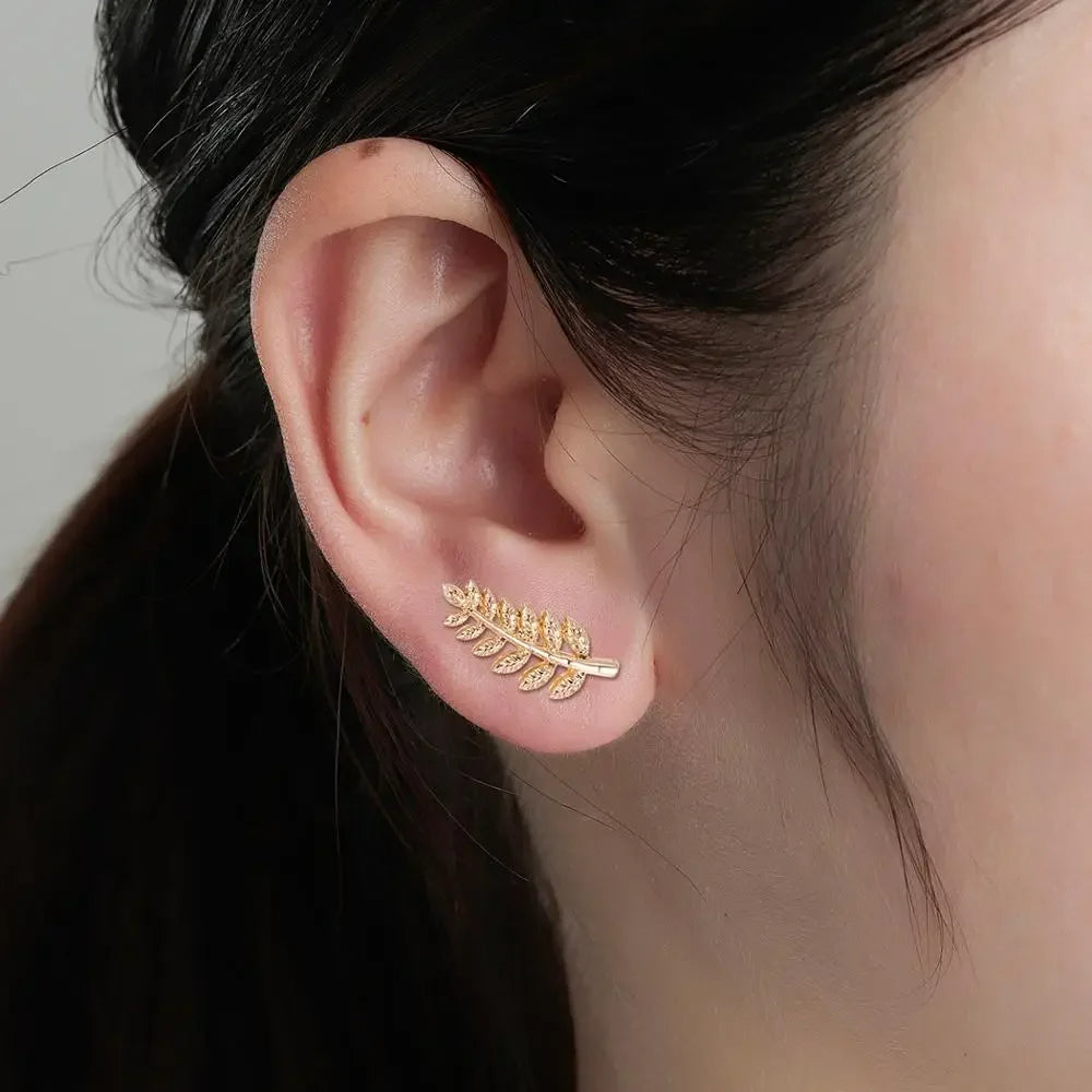 Boucle D'oreille Grimpante Acier Inoxydable Feuille d'Or, porté par une femme, on ne voit que son oreille.