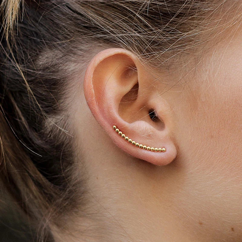 Boucle D'oreille Grimpante Constellation Dorée porté par une jeune fille, de profil on ne voit que son oreille. Image