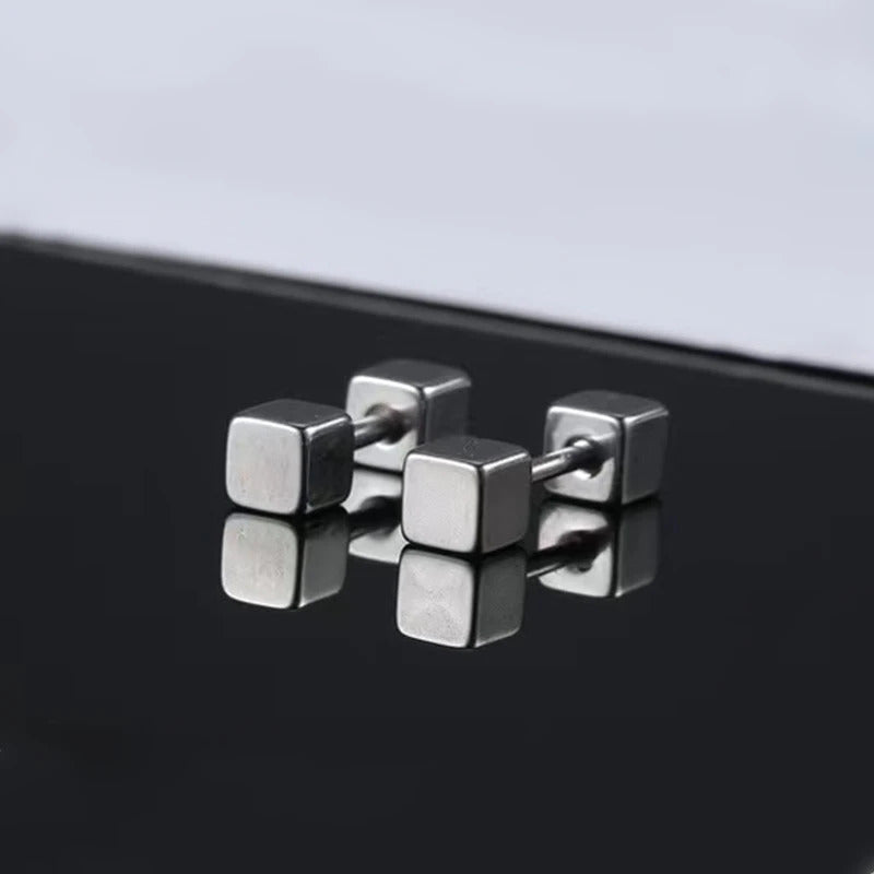 Boucle D'oreille Homme Discret en Forme de Petit Carré posé sur une table miroité Image