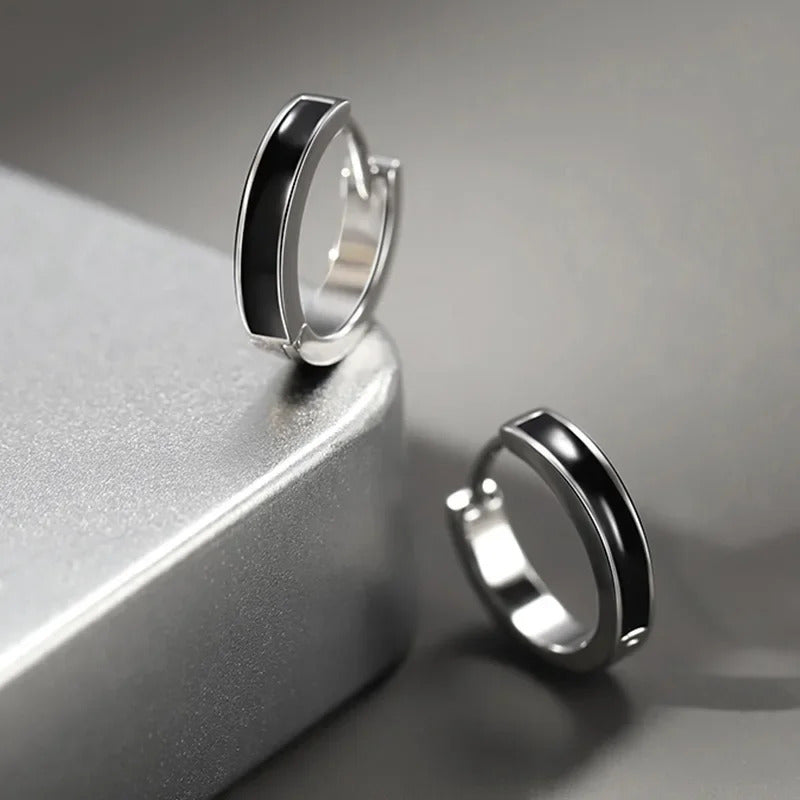 Boucle D'oreille Homme Noire Simple et Minimaliste posé sur un socle en metal