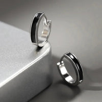 Boucle D'oreille Homme Noire Simple et Minimaliste posé sur un socle en metal