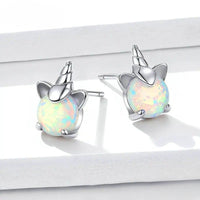 Boucle D'oreille Licorne Pierre Effet Opale sur un présentoire blanc en paire