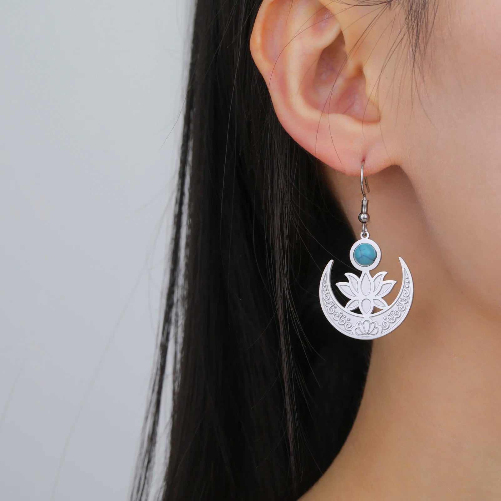 Boucle D'oreille Lune et Lotus en Acier Inoxydable, porté par une femme, on voit que son oreille