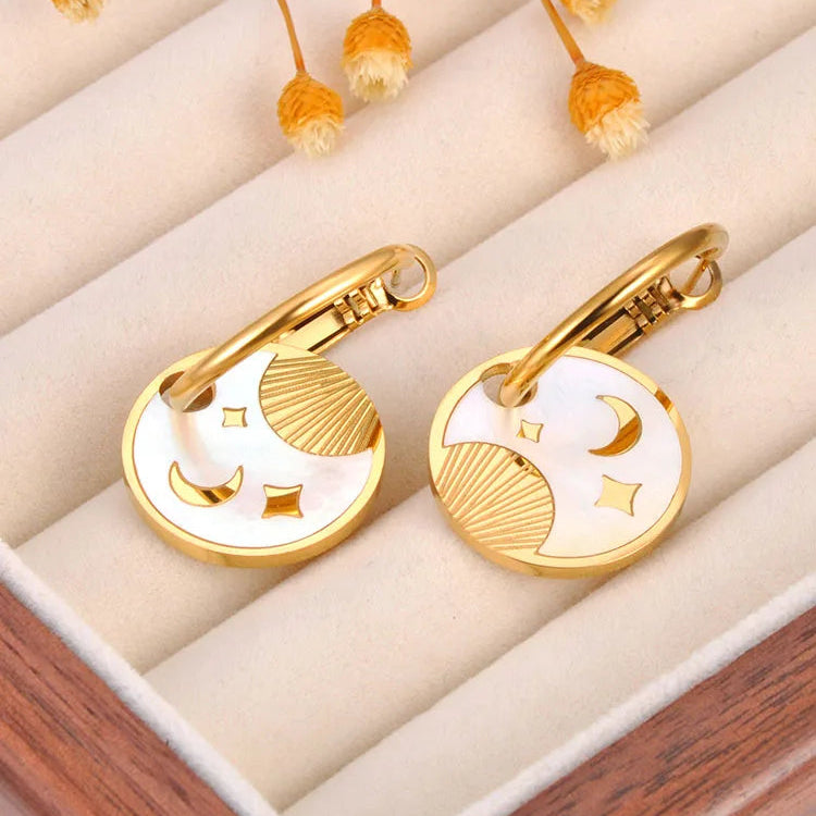 Boucle D'oreille Lune Acier Inoxydable Avec Médaillon, posé dans un écrin pour bijoux.