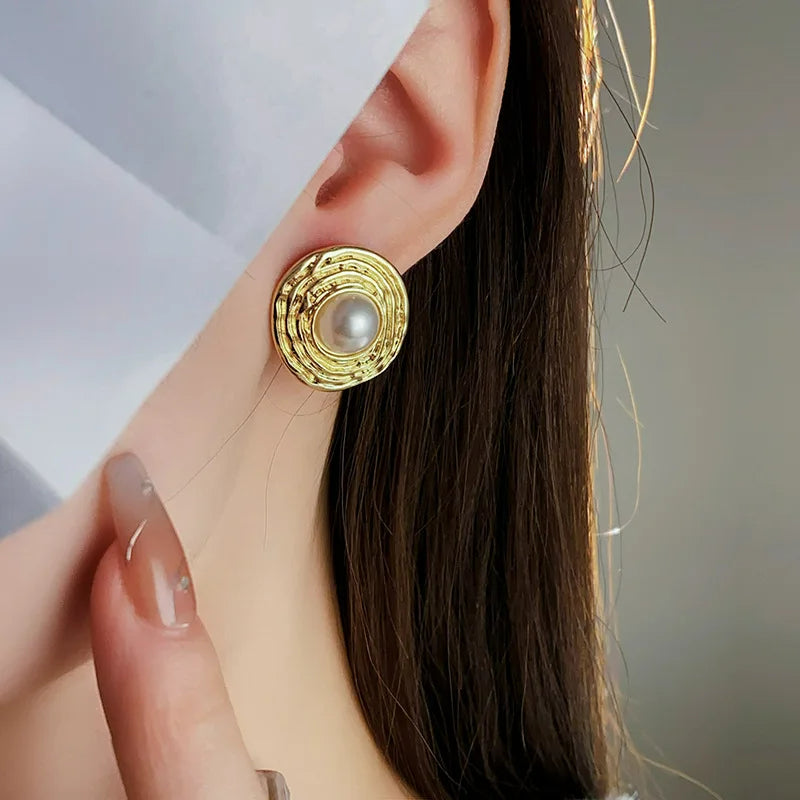 Boucle D'oreille Luxe Dorée avec Perle, porté par une mannequin aux cheveux long détachés.