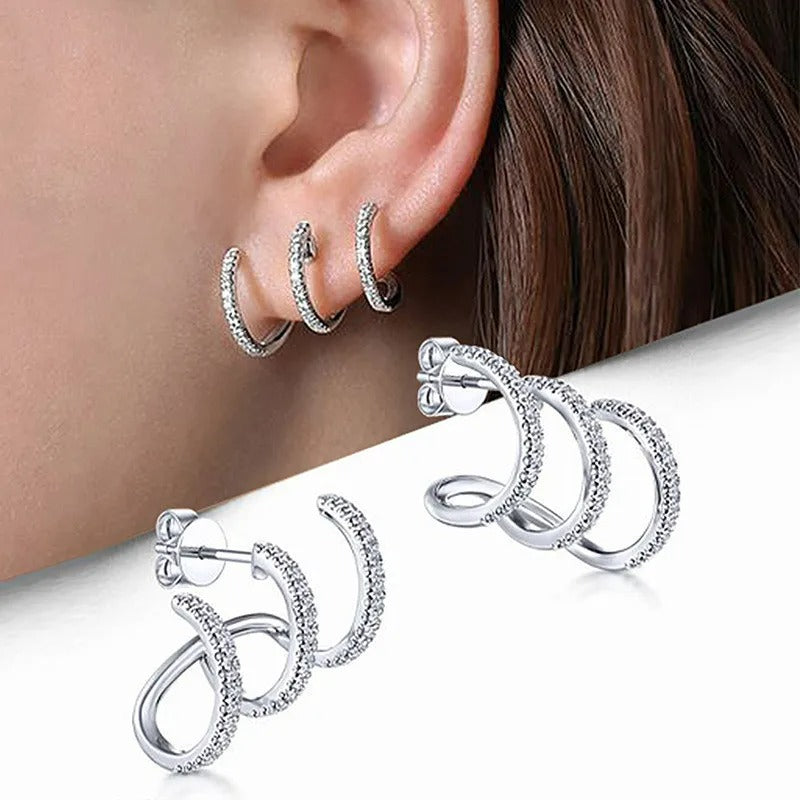 Boucle D'oreille Montante Scintillante Argentée, portée par une femme et en premier plan la paire de boucle présenté sur fond blanc