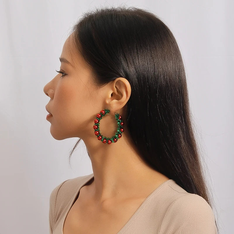 Boucle D'oreille Originale Femme Créole de Noël, portée par une femme de trois quarts pour que l'on voie bien la boucle d'oreille.