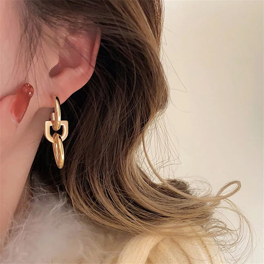 Boucle d'Oreille Pendante Dorée Minimaliste porté par une femme les cheuveux lachés