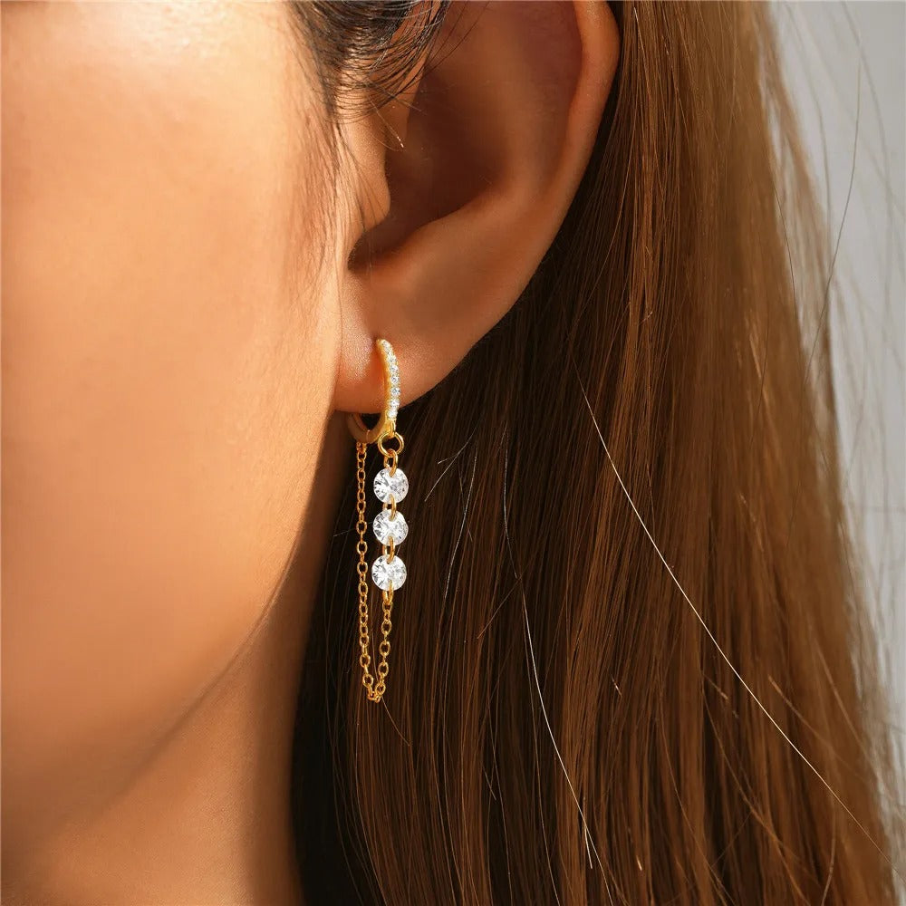 Boucle D’oreille Pendante Femme Dorée porté par une femme, on voit son oreille, ses cheveux etle bas de sa joue. Image