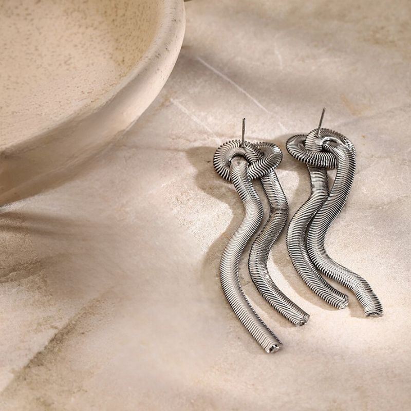 Boucle D'oreille Serpent Classique et Tendance posé sur une pierre 