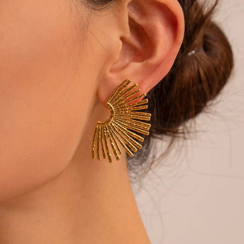 Boucle D'oreille Soleil Dorée, porté par une mannequin de profil, on ne voit que son oreille, sa nuque le bas de sa joue.