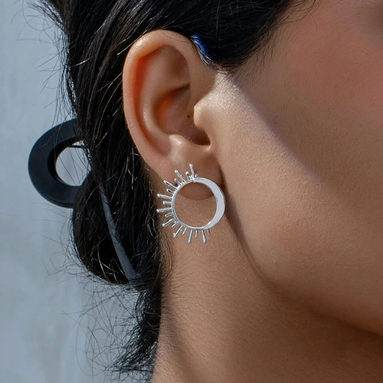 Boucle D'oreille Soleil Minimaliste argentée porté par une femme de profil