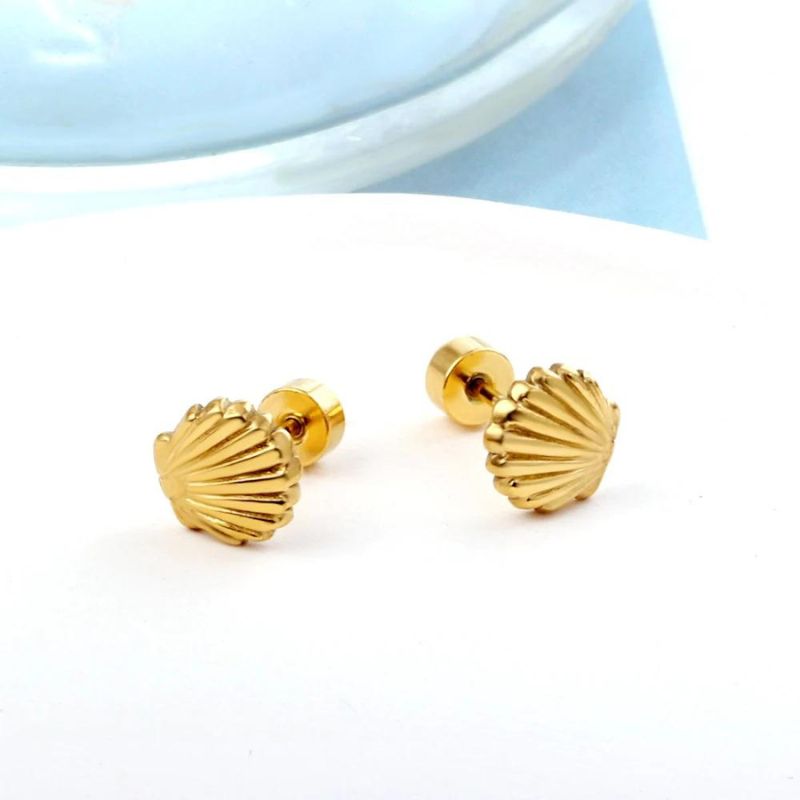 Boucle D'oreille Bebe Fille Coquillage Doré, posé sur un fond blanc. Image