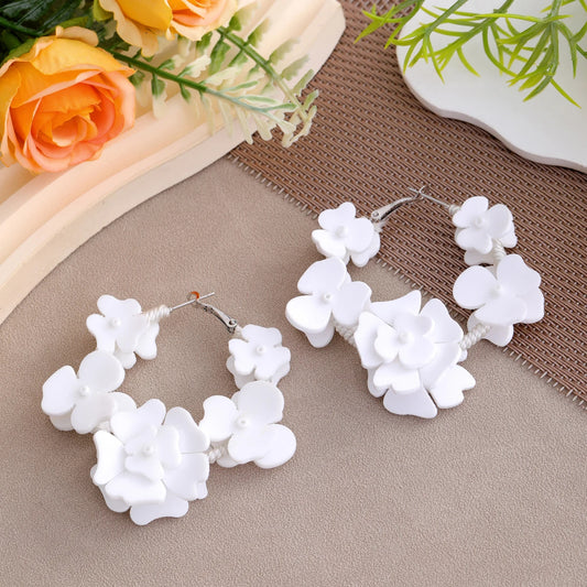 Boucle d'Oreille Blanche Chic et Tendance posée à côté de fleur