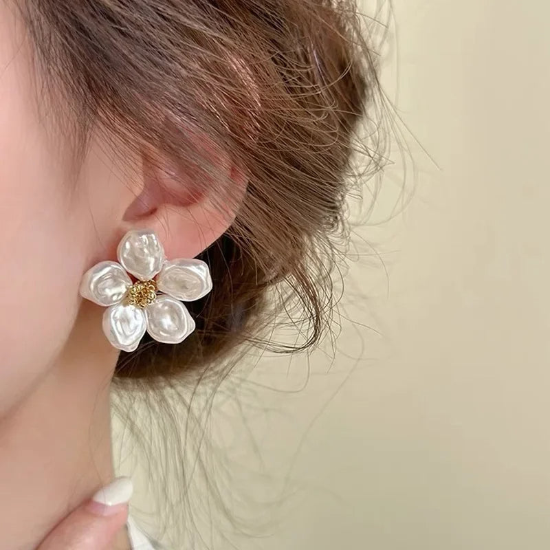 Boucle d'Oreille Blanche Raffinée au Design Fleuri portée par une femme