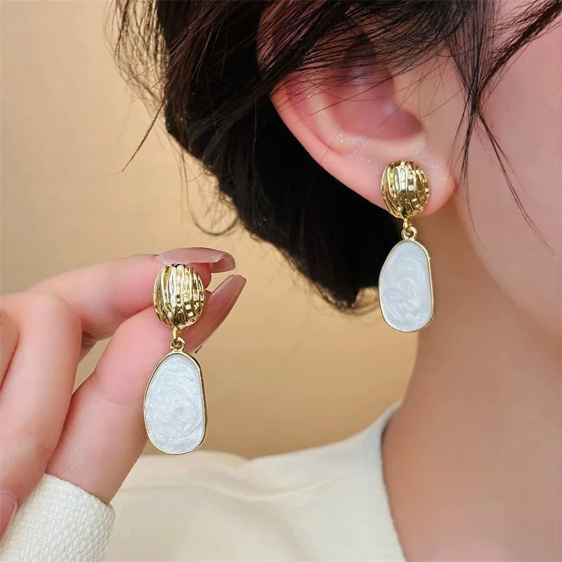 Boucle d'Oreille Blanche Vintage en Acier Inoxydable portée par une femme